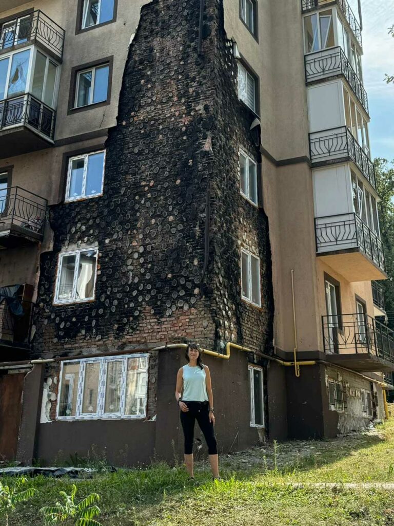 Anne-Lise in front of missile damaged building